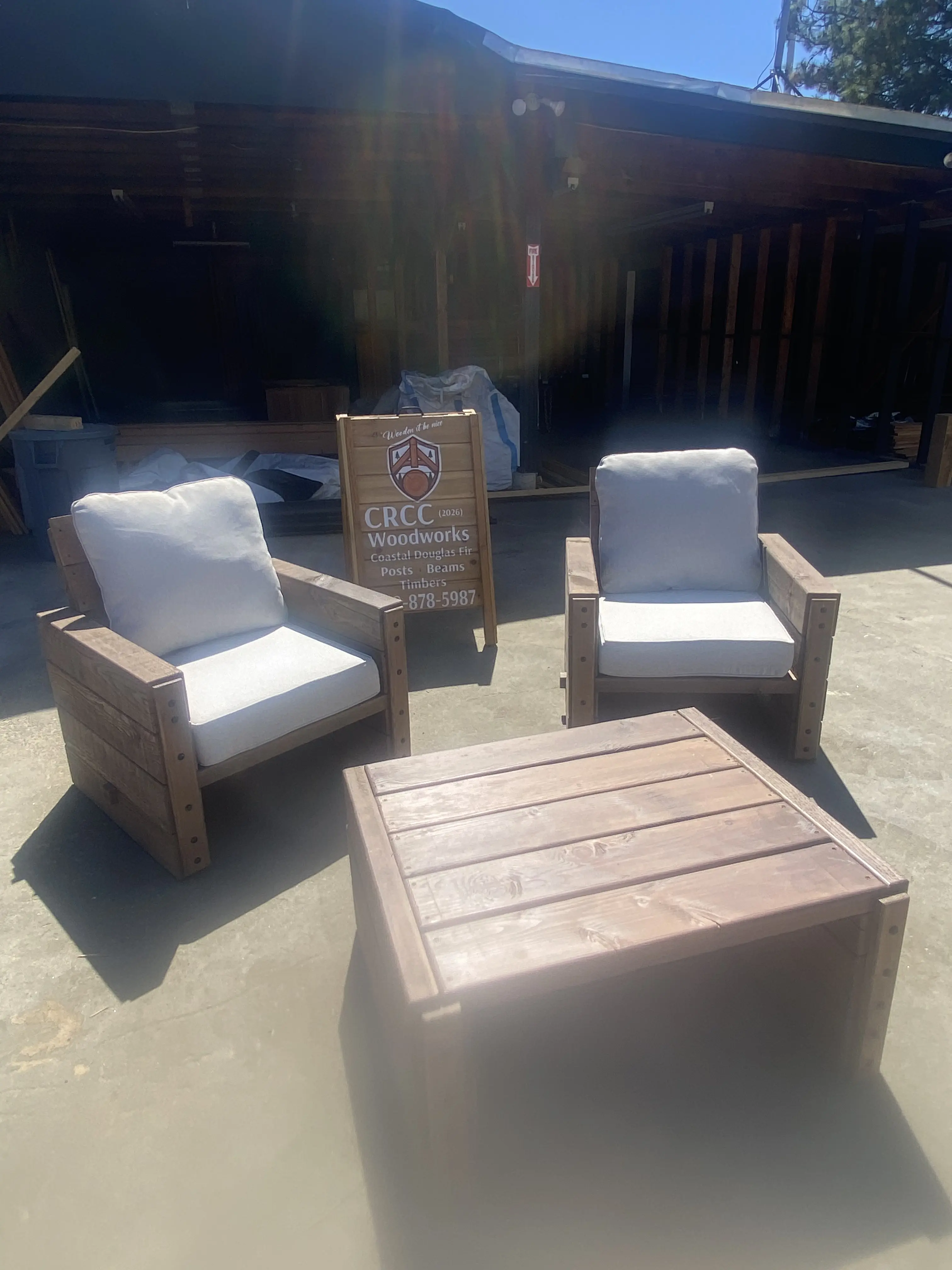 Custom outdoor lounge chairs and coffee table with CRCC Woodworks sign