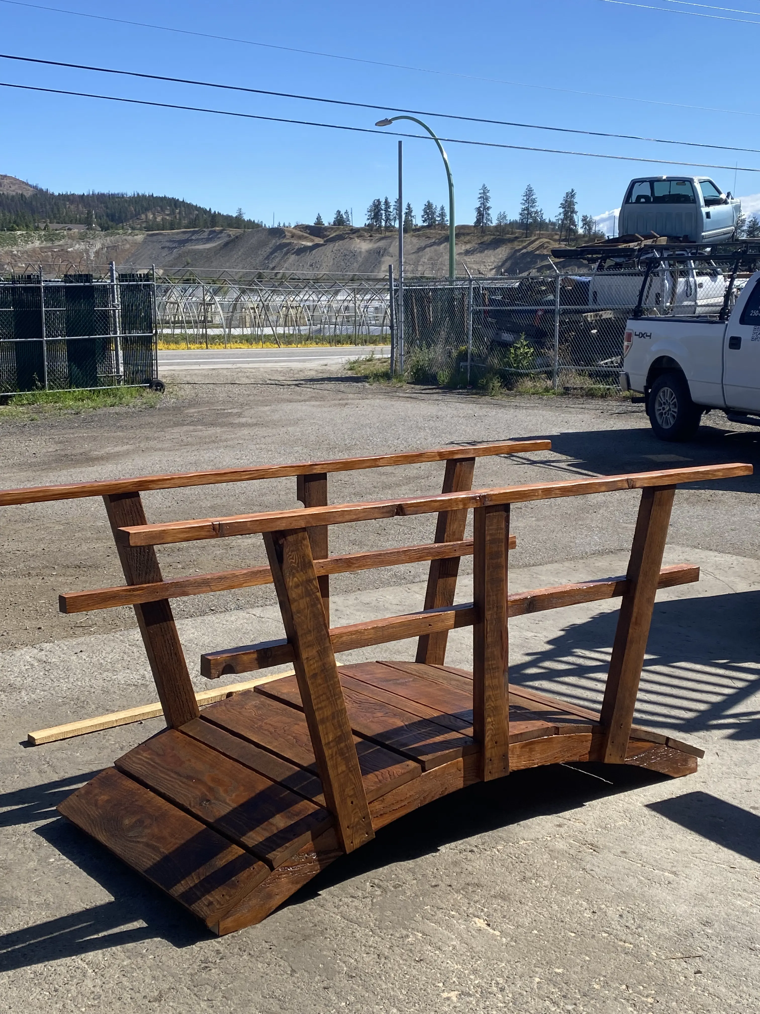 Finished dark-stained garden bridge ready for delivery