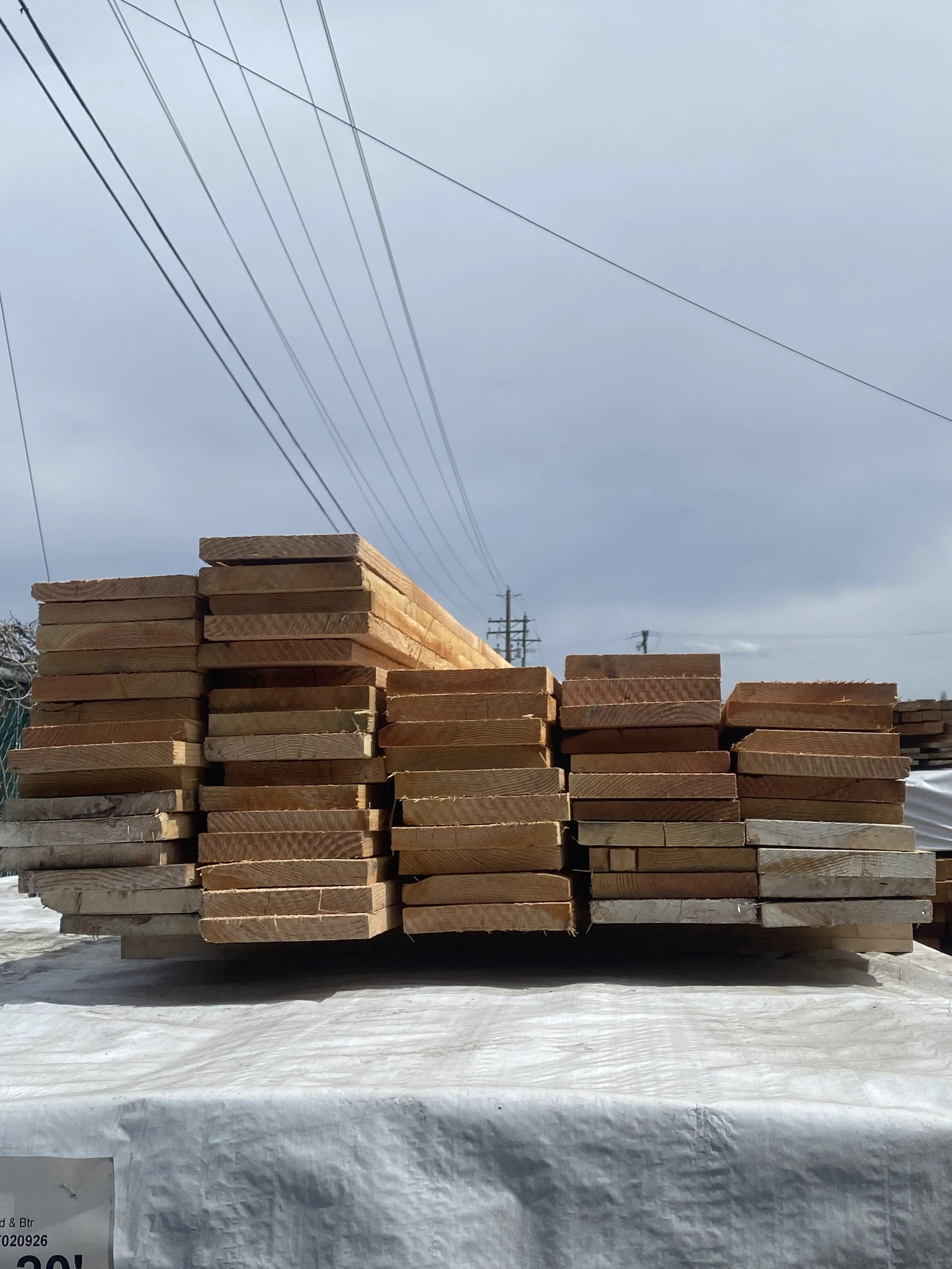 Stacked cedar decking boards on a pallet in the yard
